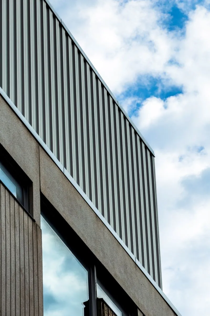 Un bâtiment en angle recouvert de couverture métallique en tôle d'acer revêtue