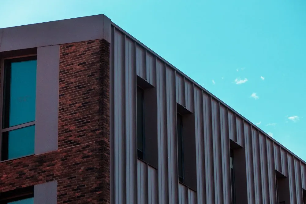 Bâtiment présentant une face en brique rouge, et l'autre recouverte de tôle de bardage