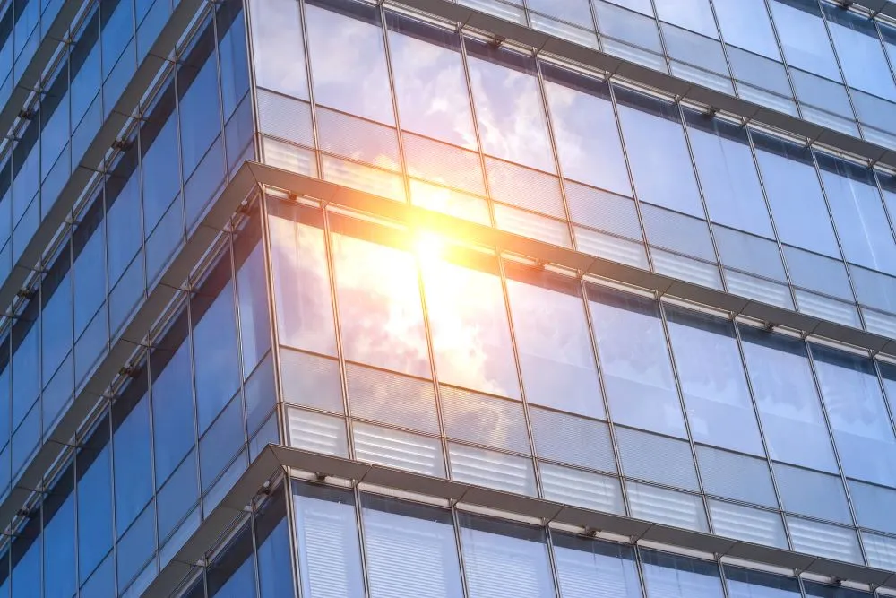 Façade d’immeuble tertiaire ensoleillée Le soleil se reflète sur la façade vitrée d'un immeuble tertiaire moderne